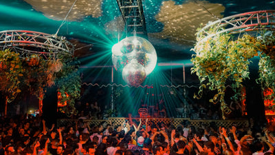 Crowd under a mirror ball and plants on the Terrace at Club Space in Miami in 2019